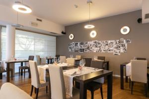 uma sala de jantar com mesas e cadeiras e fotos na parede em Da Elda Natural Retreat em Ledro