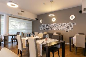 a dining room with tables and chairs and photos on the wall at Da Elda Natural Retreat in Ledro