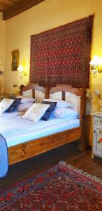 een slaapkamer met een groot bed met een houten hoofdeinde bij Casa Bertha in Sighişoara