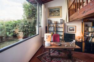 Zimmer mit einem Tisch und einem großen Fenster in der Unterkunft Independent loft on Florence's hills in Fiesole