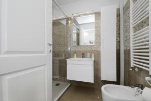 a white bathroom with a sink and a mirror at Ludovisi Barberini Grand Apartment in Rome +27 photos