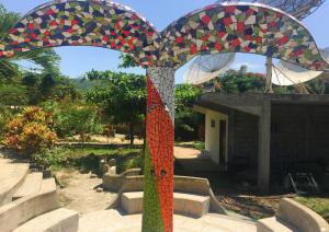 a colorful mosaic umbrella in front of a building at Bosque Marino Ecolodge in Puerto López