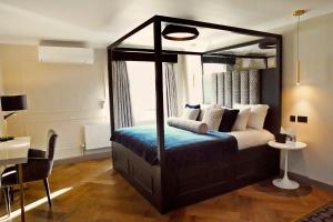 a bedroom with a canopy bed with a blue blanket at Denham Grove in Denham