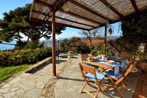a wooden table and chairs under a wooden pergola at Casa Margherita in Imperia