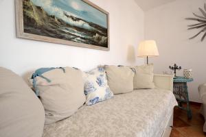 a room with a couch with pillows and a painting on the wall at Casa Margherita in Imperia +28 photos