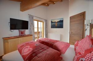 - une chambre avec un lit doté d'oreillers rouges et blancs dans l'établissement Apart Lorenz, à Häselgehr