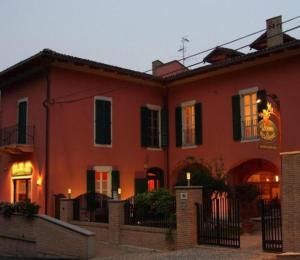a red house with a fence in front of it at La Locanda del Melograno in Moncalvo
