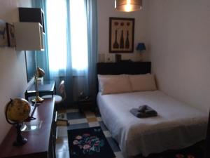 a bedroom with a bed and a desk with a lamp at primopiano BnB in Bologna