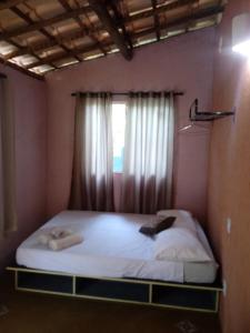 a bed in a room with a window at Complexo Halley in Lençóis