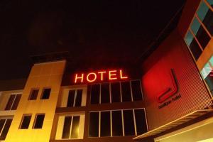 ein Hotel mit einem Neonschild auf der Seite in der Unterkunft D Boutique Hotel in Kampung Dengkil