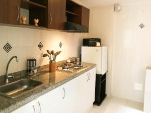 a small kitchen with a sink and a refrigerator at Aparta hotel TOCANCIPA con Parqueadero y Wifi in Tocancipá