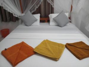 1 dormitorio con 2 camas y almohadas amarillas y blancas en Khongaha Villa Holiday Home, en Mirissa