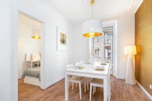 ein weißes Esszimmer mit einem weißen Tisch und Stühlen in der Unterkunft WHome | Golden Premium Apartment in Lissabon