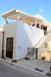 a white house with a staircase leading up to it at Casa Bianca Del Centro in San Vito lo Capo