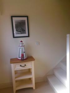 a small table with a lamp on it next to some stairs at Curlew Apartment in Valentia Island