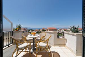 a patio with a table and chairs on a balcony at Apartments Villa Lili in Tučepi