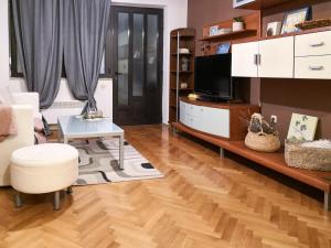 ein Wohnzimmer mit Holzboden und einem TV in der Unterkunft Apartman Oleander in Split