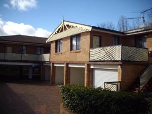 a brick house with a garage and a balcony at Estelle Kramer Motel in Armidale