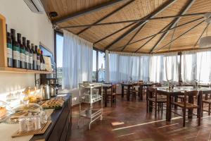 ein Restaurant mit Tischen und Stühlen und großen Fenstern in der Unterkunft B&B Eyexei Domus in Agrigento