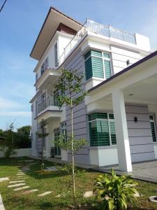 a white house with a tree in front of it at KompoVilla in Kuantan