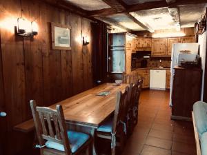 a kitchen with a wooden table with chairs and a refrigerator at Chalet Navillod in Tignes