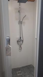 a shower in a bathroom with a black and white tile floor at Casa Particular in Banyoles