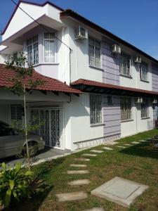 a white house with a car parked in front of it at KompoVilla in Kuantan