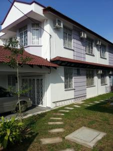 una casa blanca con un coche aparcado delante de ella en KompoVilla, en Kuantan