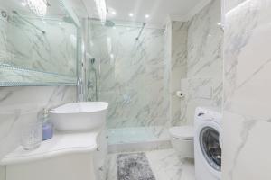 een witte badkamer met een douche, een toilet en een wasmachine bij Apartment Hannah in Novigrad Istria