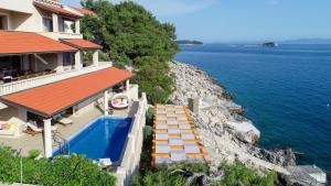 a house with a swimming pool next to the water at Exceptional Beachfront Holiday Villa on Korčula Island in Prizba