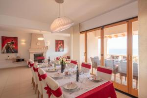 a dining room with a table with red and white chairs at Exceptional Beachfront Holiday Villa on Korčula Island in Prizba
