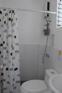 a bathroom with a toilet and a shower curtain at Celtis Resort in Malapascua Island