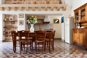 a kitchen with a table with chairs and a vase of flowers at Le Due Sorelle in Specchia