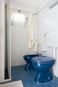 bagno con servizi igienici blu e lavandino di Le Due Sorelle a Specchia