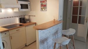 a small kitchen with a counter and two stools at CYBELE APARTMENT - HYPER CENTRE in Arcachon +9 photos