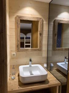 a bathroom with a sink and two mirrors at Chalet De Praz Dru in Les Houches