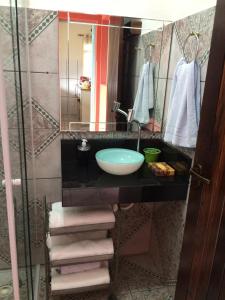 uma casa de banho com um lavatório e um espelho em Aconchego e conforto em Joanópolis em Joanópolis