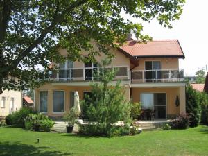 a large house with a balcony and a yard at Sunshine Beach House, DIREKT AM SEE, eigenes BOOT, PRIVATE BEACH, Grill, WLAN in Szántód
