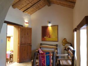 una stanza con tavolo e sedie e un dipinto sul muro di Sendero De Las Cabras a Purmamarca