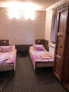 two beds in a room with pink sheets at Ararat in Zagurne