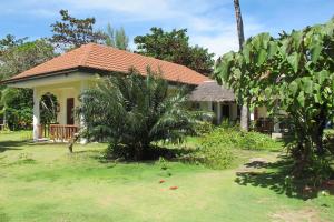 a house with a grass yard in front of it at Celtis Resort in Malapascua Island