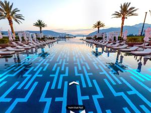 una piscina con sillas y palmeras en Milena 104, en Tivat
