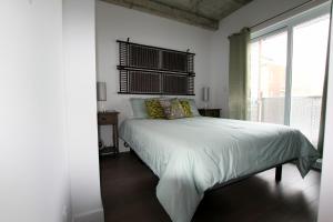 a bedroom with a white bed with a window at Condo "Imagine" - stationnement privé inclus in Quebec City