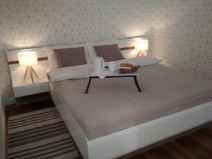 a bed with two lamps and a table on it at Anielewicza 9 in Warsaw