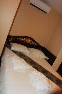a bed with white pillows and a black headboard at Uyar Apt in Istanbul