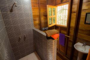 a bathroom with a shower and a sink at Alice Guesthouse in El Remate