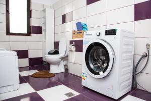 a washing machine in a bathroom with a toilet at Alex Residence in Otopeni