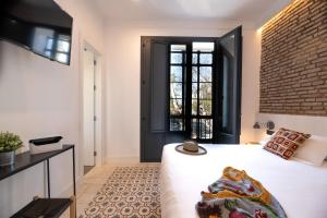 a bedroom with a white bed and white walls at Hotel Boutique La Parada del Marqués in Seville