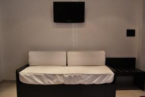Cama en habitación con TV en la pared en Casa Canale en Reggio Calabria