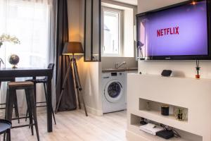 ein Wohnzimmer mit einem TV an der Wand in der Unterkunft appartement le carnel in Lorient